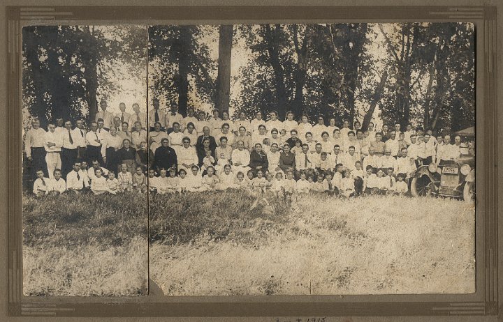 0022.jpg - Joseph C. Swartzendruber Reunion 1920 Wellman, IA.  Front:  ?, ?, Jay Yoder, ??, Nicholas Yoder [behind girl], ?? [girl], ??, ??, ??, Grace S., ??, ??, ??, ??, ??, ??, Ollie Boller Blosser, Wilma Bender, ??, Mary Ellen Brenneman, Marjorie Yoder, Ruth Brenneman, Harold, Ralph, Floyd Reschly [hand up by mouth], ?? [blurred], ??, ??, ??, ??, ?? [boy with tie], ??.  2nd sitting:  Sadie S. [Eli's wife], Katie Yoder [JK Katie], Christina Gunden S., Barbara Martin [white], Lula Martin Brenneman, holding child, ?? on lap, ?? holding child, ?? child on lap, Rebecca Yoder [white w/ribbons], Ida Swartzendruber [black], Eliza S, Lena S. [black], William Reschly [?][tie], Roy Rensenberger, holding child/Leonard, Leonard Rensenberger sitting on lap, Maynard Brenneman [?], John Schrock [married to Ruth S.], William Eicher [Will], Christian S., ??, ?? on lap.  Standing first row:  John Y. Yoder, Orval S, Jake Boller, Willard Boller, Jay [Jason]Boller, William Harvey S. folded arms, ??, [standing behind], ?? woman, Eli Yoder [behind, rt of woman], 2nd woman Lydia Eicher, Nora Gingerich, Mary Boller [cape dress, head turned left], ??, ??, Lovina Miller [Viney--Husband was Viney Dan], Sadie S, Ida S, Anna Yoder--sisters, in-laws from MO., Wilber Yoder being held, Katie S. Reschly, holding Ruth R, Ruth Reschly being held, Ethel Bender, Ruth Schrock, Ida Schrock, Lovina Gingerich, ?? holding child, ?? child being held, Mamie Rensberger, Ed Martin, Charles Martin [boy being held], Irving Bender holding Delmar, Delmar Bender being held, John S., ??, [in the vest behind], Joe Swartzendruber [bald], Emroy Yoder.  Back Row:  ??, ??, Lloyd Yoder, Quinton Yoder, Joe Erb [bow tie], Louisa S., ??, ??, Emma Yoder [w/out covering], Bertha S. Yoder, Clara Gingerich [Rogers], Eliza Brenneman, Carrie S., Sadie Yoder, ?? glasses, ??, ??, Ona Yoder, ?? tie/suit, Merton Yoder, ??, ??, ??.