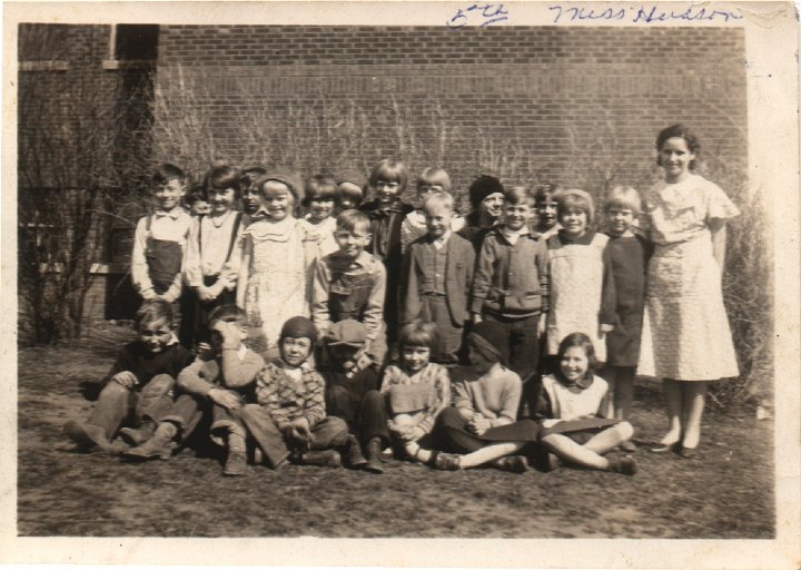 0060.jpg - Olds School   3rd, 4th, & 5th grade class with Edna Reschly  Miss Hudson, teacher  1930c  sitting l/r:  Gerald Rogers, ???, George Miller, ???, Wanda Roth Brown, ???, Winona Tolander.standing front:   Clarence Unkrich, Mary Lillian Unkrich, Maysil [?] Dewitt, stooped down, Roger Canel[?], standing back, Vicky Bergstrom, Mary Evelyn, front standing w/suit ? Leese, behind standing black hat Edna Reschly, front standing boy ???, back standing Arlene Johnson, front standing light dress Marion Palm, end standing Josephine Hultquist.  Miss Hudson