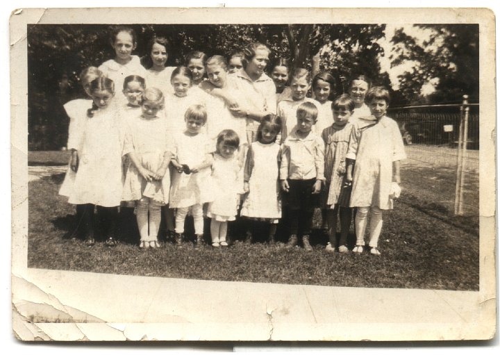 0204.jpg - Swartzendruber Reunion--Children of 3 Sisters.  1920Back row left: Bertha Gingerich, ???, ???, Kathryn Schrock peeking thru; ???, Lola Von Bontrager.  Middle row:  ???, ???, ???, Bernice Schrock, Verda Gingerich [taller], ???, ???.  Front row:  ???, Isabelle Schrock, Geneva Ann, ???, ???, Freeman Schrock, ???, ???.