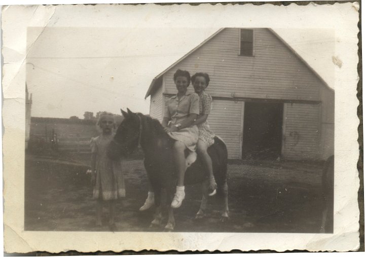 0111.jpg - Aldine Eichelberger and Edna Reschly on pony held by Margaret Sandeen.  At Sandeen's house. 1940c