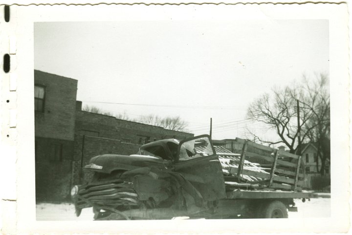 1236.jpg - Wrecked 54 Chevy 1 ton dualie truck driven by Levi Roth with Ray Roth as passenger.  They were taking a load of Easter lambs to market in Waterloo, IA.  A semi jack-knifed on ice, and the trailer slammed into them.  Levi was pinned inside and Ray was thrown from the truck.  Gas leaked from the tank and a fire started under the truck where Levi was.  George Widmer came by in a semi and put out the fire with his fire extingisher.  This occurred 1/2 mi north of Coralville Lake on old 218.  The truck was in a wrecking yard in Iowa City, IA.  1956