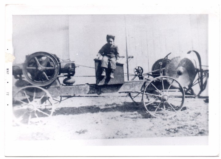 1546.jpg - Floyd Reschly sitting on steam powered buzz saw.  1918c