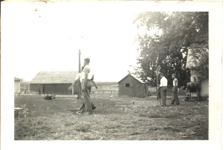 0097.jpg - Playing horseshoe  1940c  Ray Roth on left; Marlin Wyse on right at the Roth Place on Hwy 78.  Cider mill is in the background.