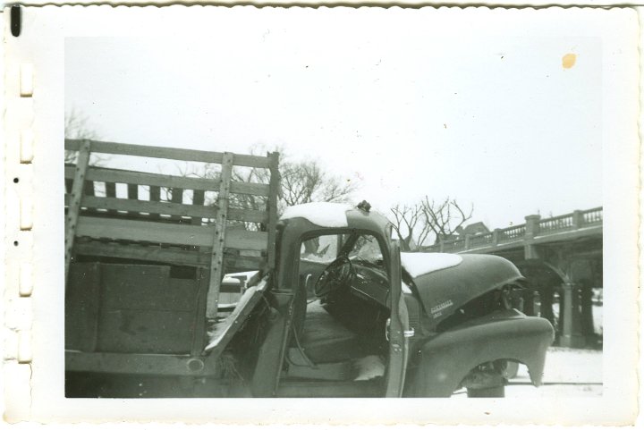 1234.jpg - Wrecked 54 Chevy 1 ton dualie truck driven by Levi Roth with Ray Roth as passenger.  They were taking a load of Easter lambs to market in Waterloo, IA.  A semi jack-knifed on ice, and the trailer slammed into them.  Levi was pinned inside and Ray was thrown from the truck.  Gas leaked from the tank and a fire started under the truck where Levi was.  George Widmer came by in a semi and put out the fire with his fire extingisher.  This occurred 1/2 mi north of Coralville Lake on old 218.  The truck was in a wrecking yard in Iowa City, IA.  1956