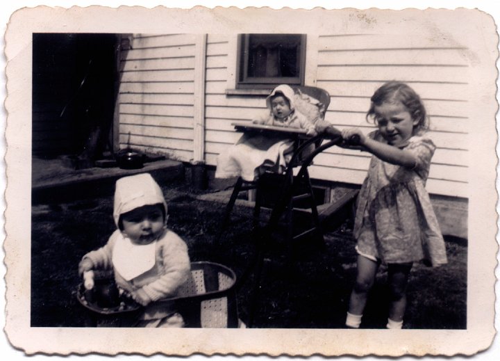 1589.jpg - Fred Roth in stoller, Joanne Reschly in high chair, Louise Reschly pushing stroller.  1946