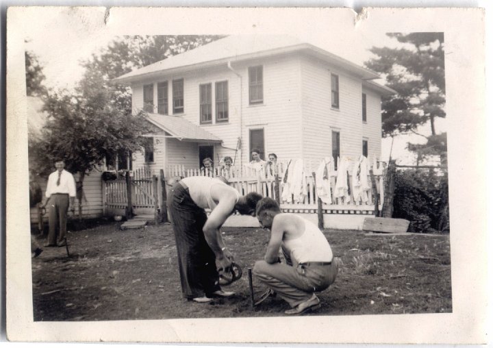 1605.jpg - Behind the fence:  Dorothy Roth, Miriam Swartzendruber, Alice Eichelberger, & Irene Reschly watching 3 unknown men & Ray Roth playing horseshoe.  1935c  Brown Album