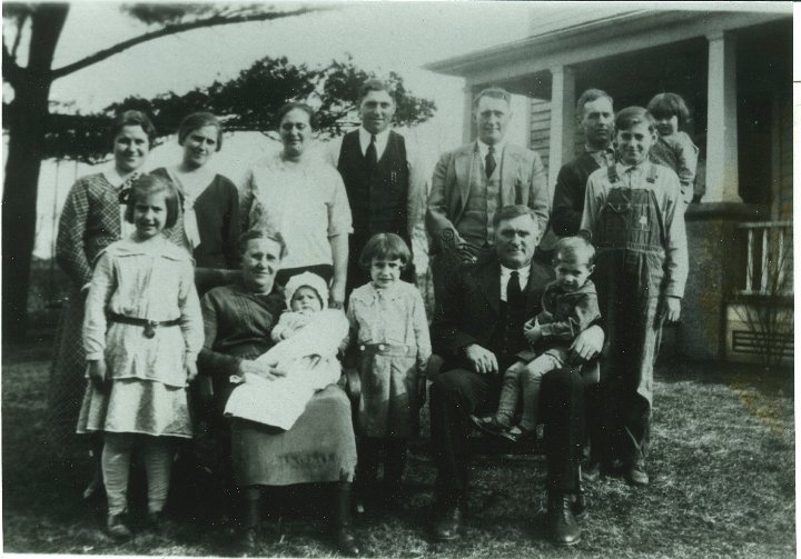 1302.jpg - Joseph & Fannie Roth Family:  back left:  Elsie, Helen, Mary R. Swartzendruber, Orie, Levi, Earl holding Mariam Swarzendruber, Ray Roth.  Front left:  Marie Swartzendruber, Fannie holding James, Dorothy, Joseph holding Max Swartzendruber.   Taken at the home place.  1932c  Scanned from a copy whose original source is unknown.