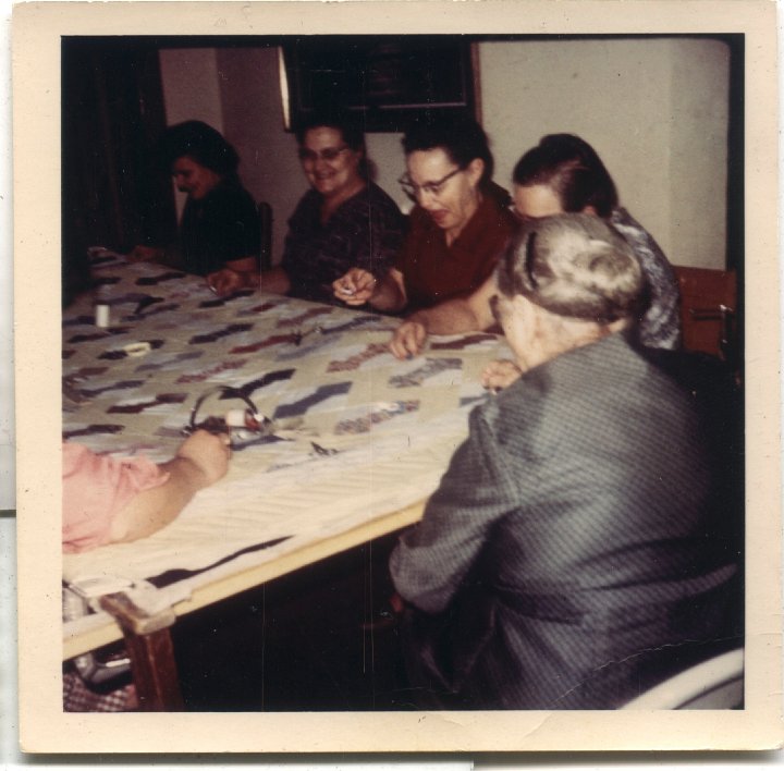 0675.jpg - Quilting Necktie Quilt for Lynn.  Katie Reschly front with back towards camera, Esther Reschly, Wilma Roth, Mayme Roth,  ???  1968c  unknown   [set 0413]