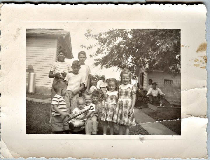 0918.jpg - Reschly Cousins:  Back, left:  Ed, Gary, Richard, girls right:  Joanne, Louise Reschly; wagon:  Larry, Fred Roth, Kenny Reschly, front standing:  Dudley Pankoke [Striped shirt].  Back center, distant:  William Reschly.  Right distant front to back:  Ralph Reschly, Elgin Pankoke, ???.  1950c